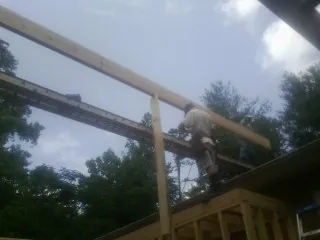 Carpenter setting a ridge beam over a new addition frame — Ice Dam Removal by Roofing Brothers in Sparland