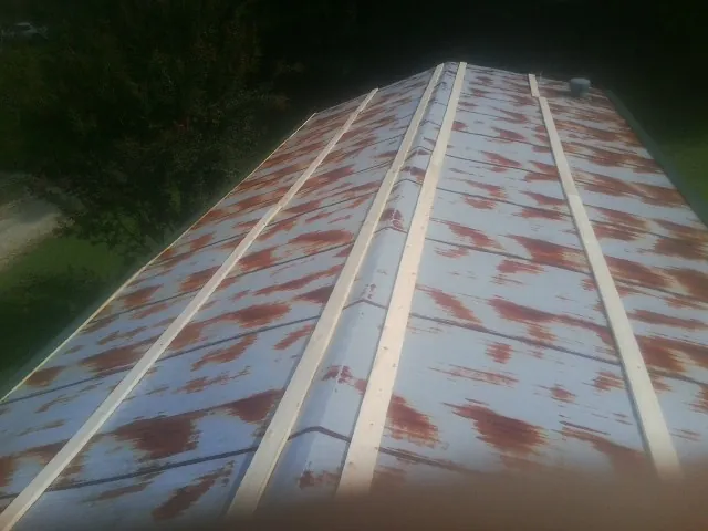 Rusted metal roof panels with new wood purlins before replacement — Storm Damage Roof Repair in Sparland by Roofing Brothers