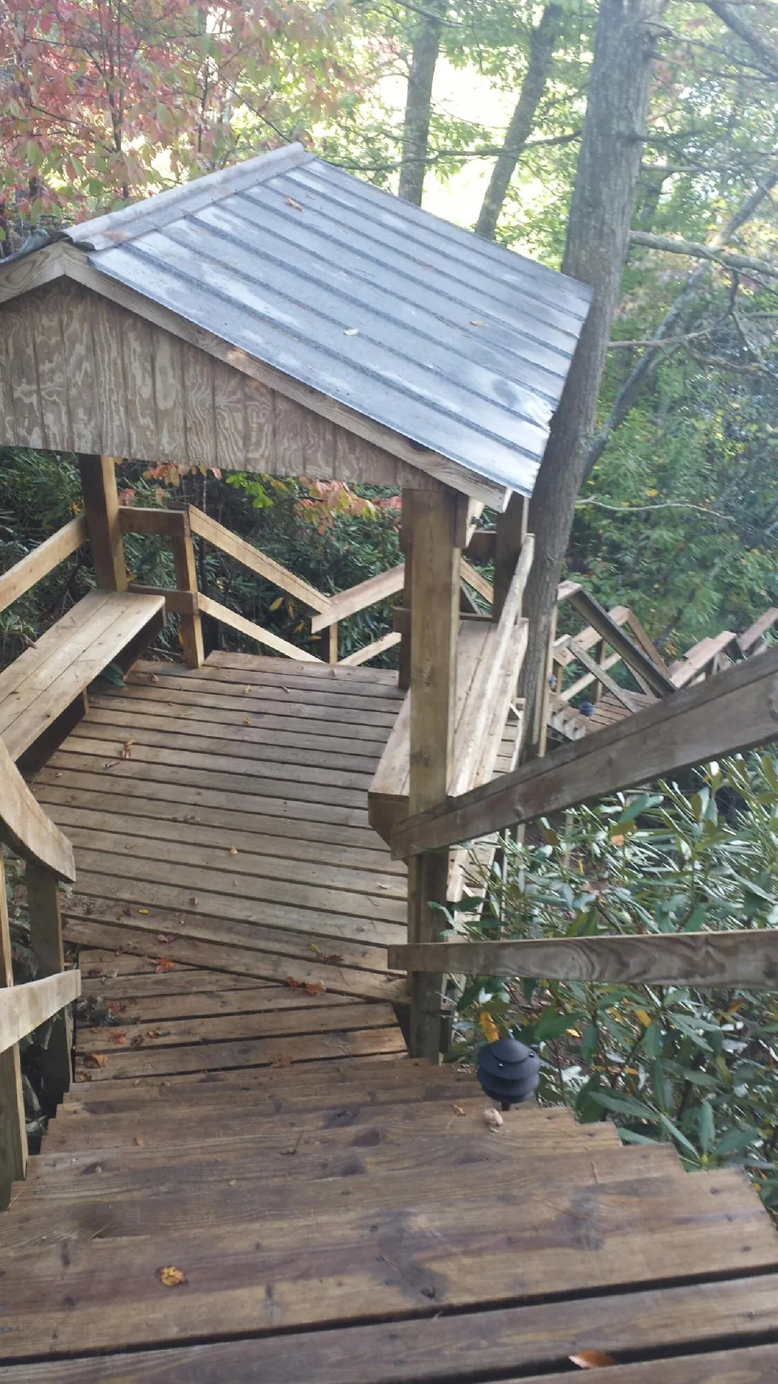Metal roofed shelter over wooden steps on a wooded walkway — Skylight Repair & Installation work by our crew in Sparland