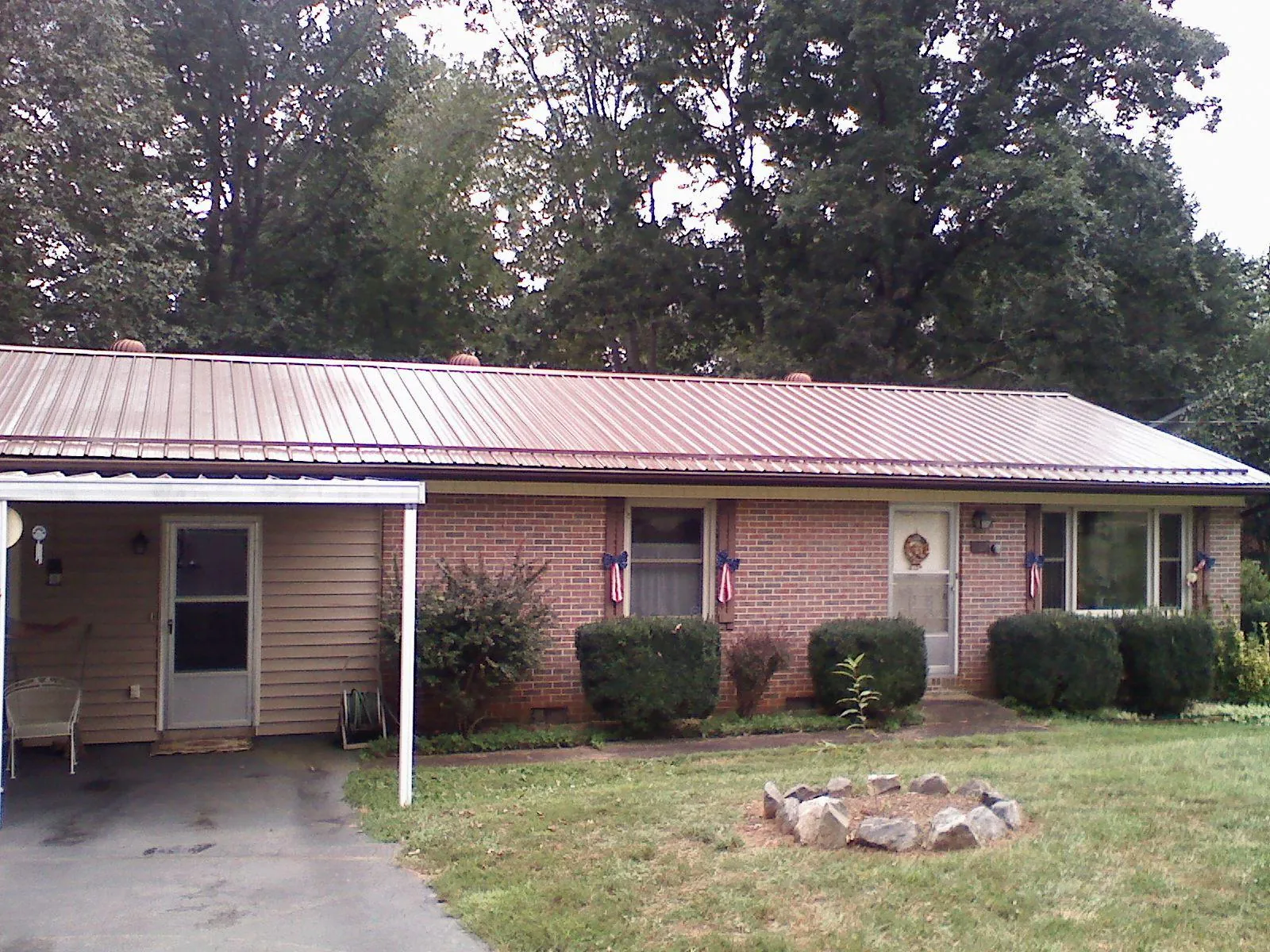 Bronze metal roof and carport on a brick ranch home — Roof Repair work by our crew in Sparland